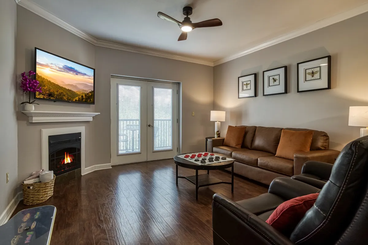 A cozy living room featuring a plush sofa, a stylish coffee table, a flat-screen television, and a fireplace. The arrangement encourages conversation and entertainment, making it ideal for family movie nights or catching up with friends.