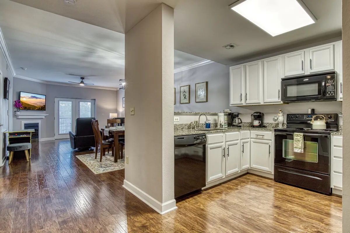 This image showcases an open-concept living area that seamlessly combines the kitchen, dining, and living spaces. Comfortable seating, a modern dining table, and inviting decor set the tone for socializing, shared meals, and relaxing evenings. The space is flooded with natural light, enhancing the warm and welcoming ambiance.